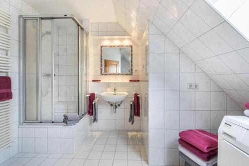 a white bathroom with a sink and a shower at Bi uns to hus - Morgensünn in Nordstrand