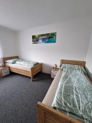 a bedroom with two beds and a picture on the wall at Haus Rose in Kaisersberg