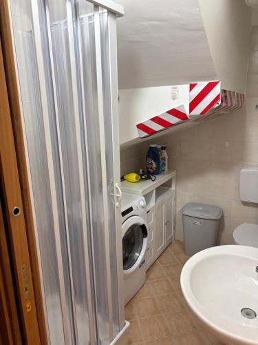 a bathroom with a washing machine and a washer at Villa Romano Cirella in Cirella