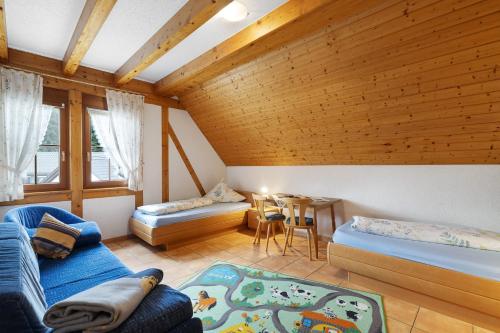 a living room with two beds and a table at Löcherhansenhof in Bad Peterstal-Griesbach