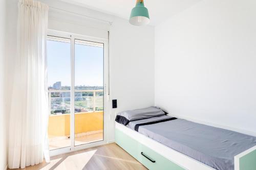a bedroom with a bed and a large window at Ático en Canet-playa in Canet de Berenguer