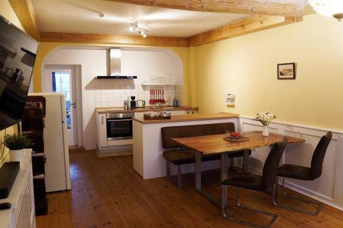 a kitchen with a wooden table and a dining room at Ferienwohnung im Hofratshaus in Schrozberg