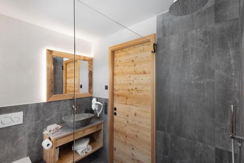 a bathroom with a sink and a mirror at Chalet-Suite Wiese in Selva dei Molini