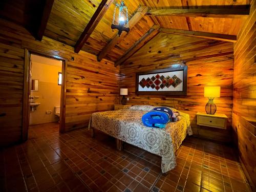 a bedroom with a bed in a wooden cabin at La Huerta in Mazamitla