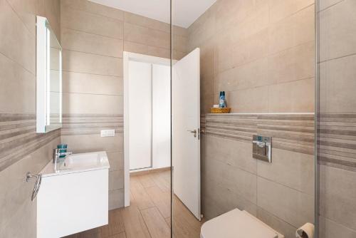 a bathroom with a toilet and a glass shower at Orlando 314 in Adeje