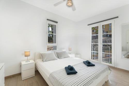 a white bedroom with two towels on a bed at Orlando 314 in Adeje