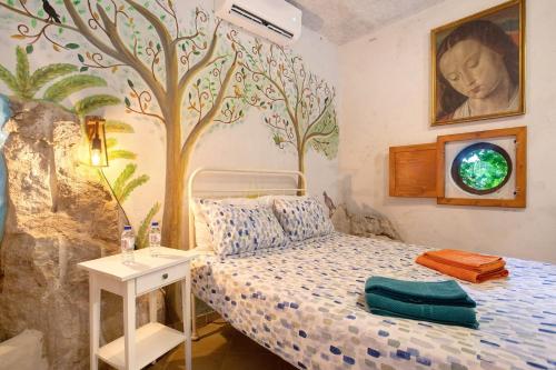 a bedroom with a bed with a tree mural on the wall at Quinta do Castelo - Casa de Pedra in Reguengo Grande