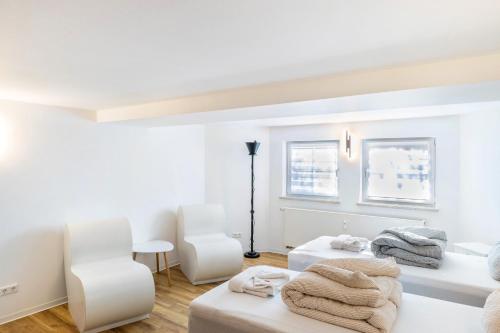 a white room with two beds and two chairs at Haus am Eschenbach in Lindenberg