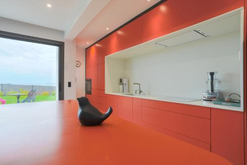 a kitchen with red cabinets and a black chair at Villa Ker Marie in Locquirec