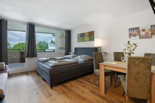 a living room with a bed and a dining room table at Appartement Hella Wahnsinn in Sankt Englmar