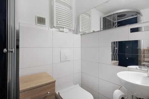 a white bathroom with a toilet and a sink at Appartement Hella Wahnsinn in Sankt Englmar