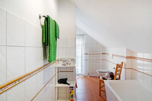 a bathroom with a green towel and a tub at Seeschwalbe Hilgenriedersiel in Hagermarsch