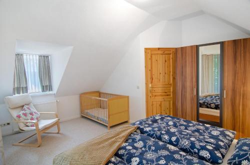 a small bedroom with a bed and a chair at Seeschwalbe Hilgenriedersiel in Hagermarsch