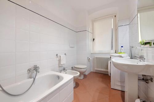 a bathroom with a tub and a sink and a toilet at Lake view Domaso in Domaso