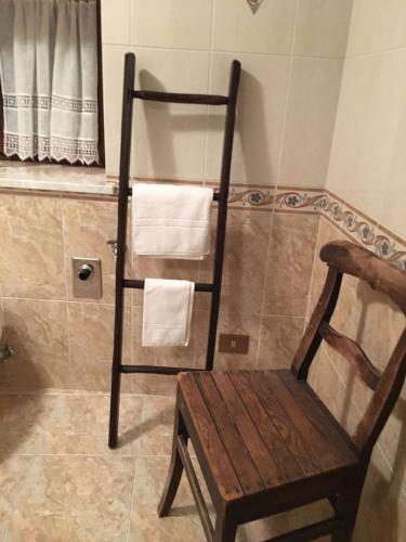 a chair and towel rack in a bathroom at Maison Perruchon in Pont-Saint-Martin