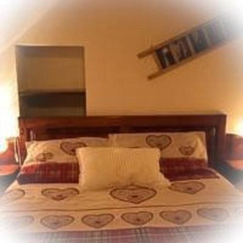 a bed with a wooden headboard in a bedroom at Maison Perruchon in Pont-Saint-Martin