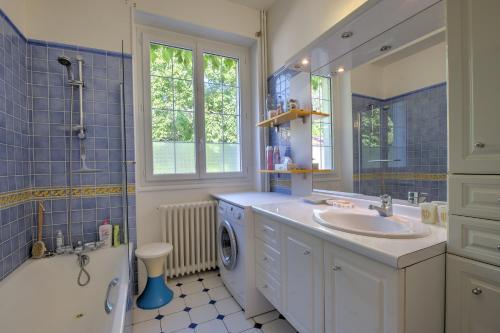 a bathroom with a sink and a washing machine at Magnifique maison à Ribérac in Ribérac