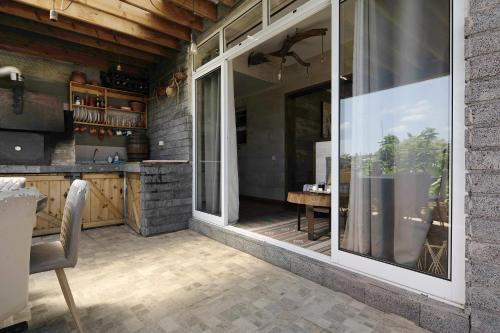 a patio with a large window and a table at Casa de Férias Garrett in Lagoa