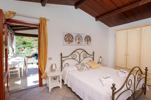 a bedroom with a bed and a table and chairs at Casa Euforbia in Orosei