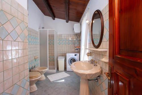a bathroom with two toilets and a sink and a mirror at Casa Euforbia in Orosei