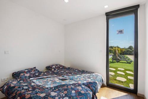 a bedroom with a bed and a large window at Apartamento Thaï com Piscina in Apúlia