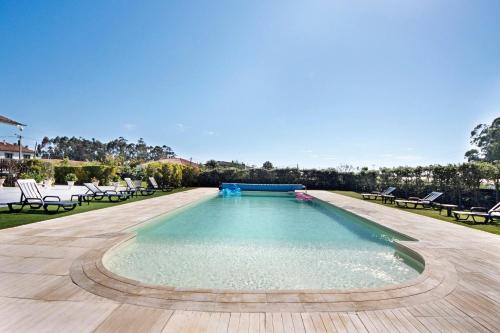 a large swimming pool with chairs in a yard at Apartamento Thaï com Piscina in Apúlia