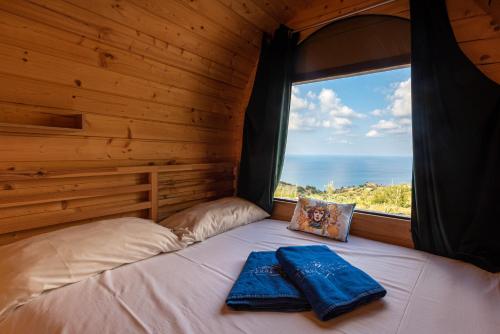 a bed in a wooden room with a window at Terre di Tusa in Tusa