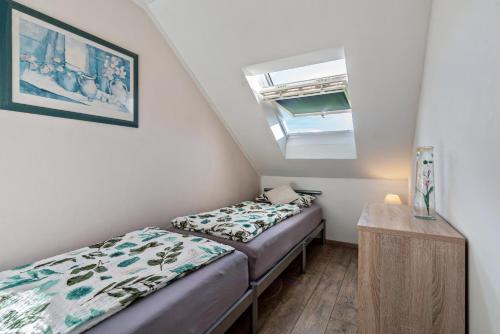 two beds in a small room with a window at Ferienwohnung Hobmaier in Forstern