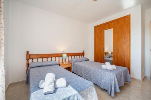 a bedroom with two beds with towels on them at Apartamentos Karin 1ºc in Cala d´Or