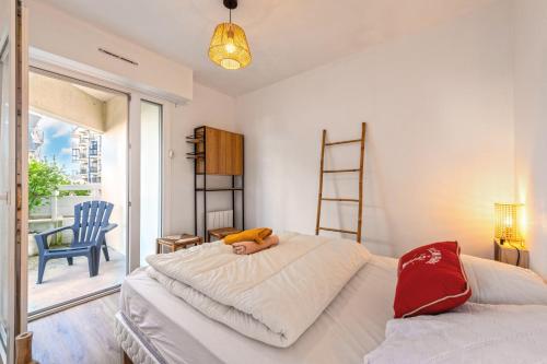 a bedroom with two beds and a chair and a window at Appartement 4 pers 50m de la plage in Plougonvelin