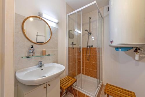 a bathroom with a sink and a shower with a mirror at Appartement 4 pers 50m de la plage in Plougonvelin