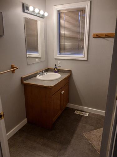 a bathroom with a sink and a mirror at Grumpy's Suite by the Lake in Summerland