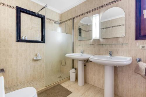 a bathroom with two sinks and a shower at Entre Caballos in Cumbre del Sol