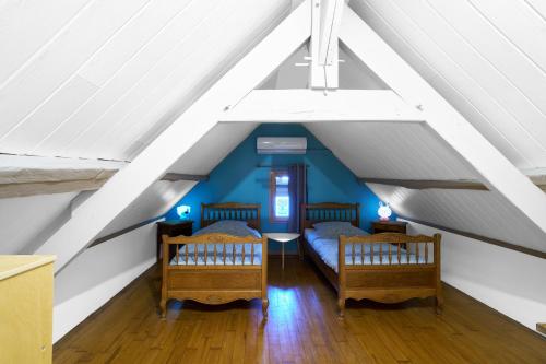 a attic room with two beds and a table at Domaine De Vic in Saint-Chamassy