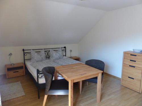 a bedroom with a bed and a wooden table and chairs at Haus Schwärzler in Stiefenhofen