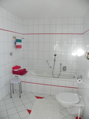 a white bathroom with a tub and a toilet at Haus Schwärzler in Stiefenhofen