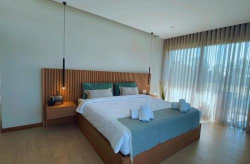 a bedroom with a large bed with blue pillows at Ria Lounge House in Torreira