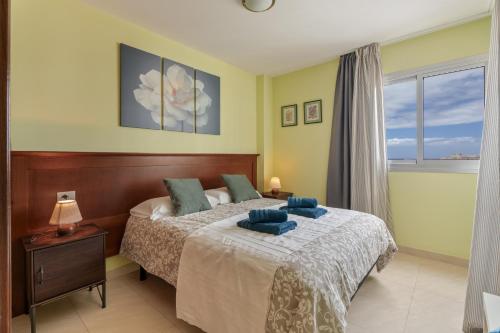 a bedroom with a bed with blue pillows on it at Apartamento Sol Paraiso in Adeje