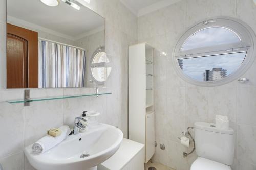 a white bathroom with a sink and a mirror at Apartamento Sol Paraiso in Adeje