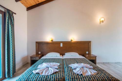a bedroom with a bed with two pillows on it at Mirage Arillas Studio Type C18 in Arillas