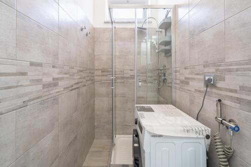 a bathroom with a shower with a toilet and a sink at Le Quattro Perle Apartments in Pachino