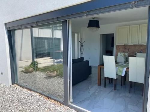 a sliding glass door of a living room with a table at Počitniška hiška SEA HIDEAWAY in Ankaran