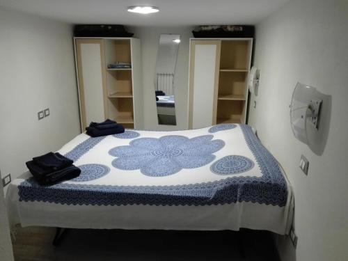 a bedroom with a bed with a blue and white blanket at bilocale con il mare dentro in Bonassola