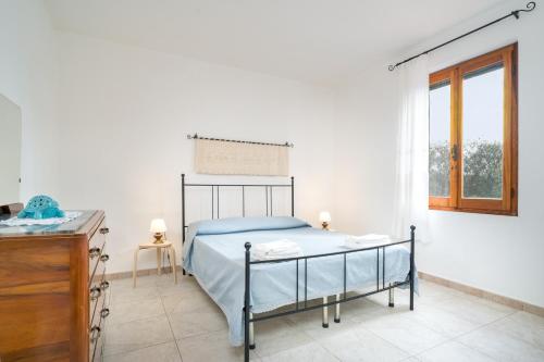 a bedroom with a bed and a table and a window at Villa Francesco P Terra in Orosei