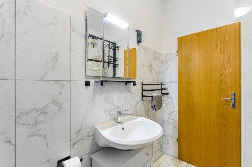 a white bathroom with a sink and a mirror at Ferienwohnung Astrid in Sundern