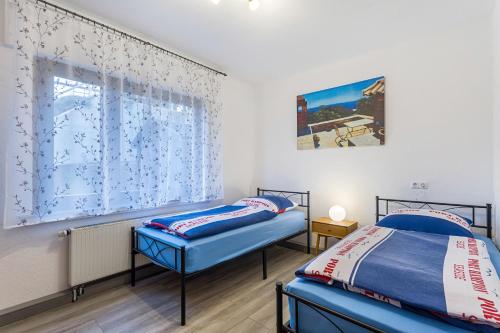 two twin beds in a room with a window at Ferienwohnung Astrid in Sundern
