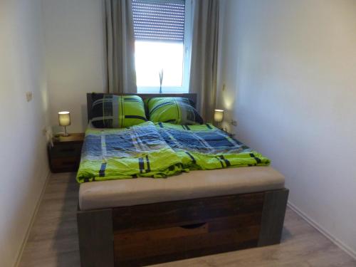 a bedroom with a bed with green sheets and a window at Ferienwohnung in Hof Saale in Hof