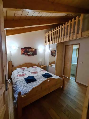 a bedroom with a bed with blue pillows on it at Charming Chalet 3 étoiles - 10 pers in Courchevel