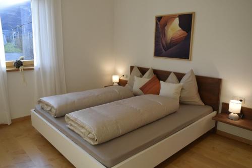 a bed sitting in a room with two lamps at Appartment Gut Wendlandt in Bolzano