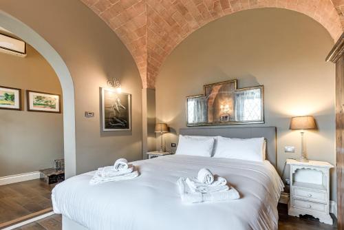 a bedroom with a large bed with towels on it at Pretty Suite Firenze Fiesole in Florence